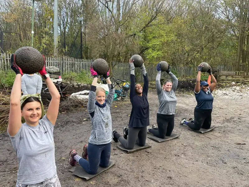 A Bootcamp SE16 member slamming a medicine ball down mid-rep at Stave Hill